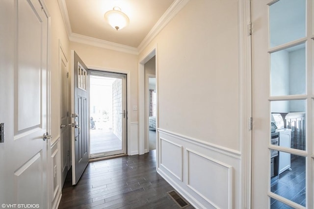 entryway with dark wood-style flooring, wainscoting, a decorative wall, visible vents, and ornamental molding