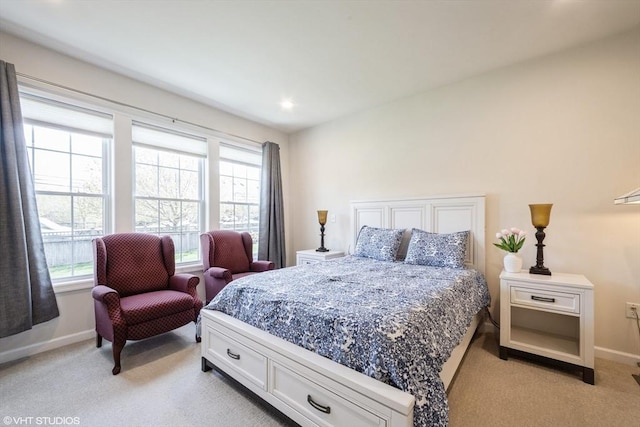 bedroom with light colored carpet, baseboards, and multiple windows