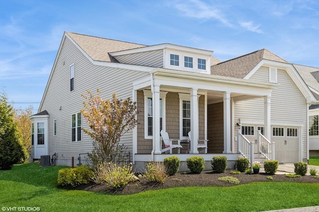 view of front of property featuring covered porch, cooling unit, a front lawn, an attached garage, and a shingled roof