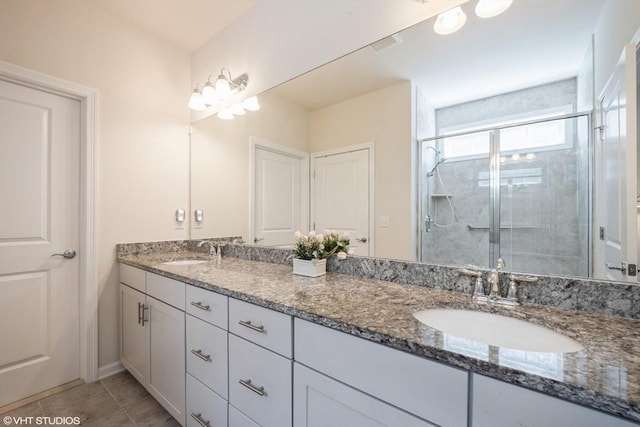 full bath featuring a sink, tile patterned floors, a shower stall, and double vanity