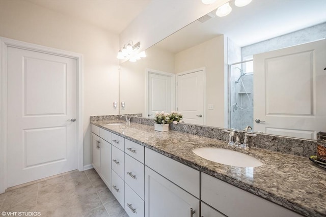 bathroom with a sink, a shower stall, and double vanity
