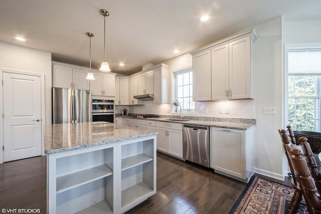 kitchen with open shelves, under cabinet range hood, white cabinets, light stone counters, and stainless steel appliances