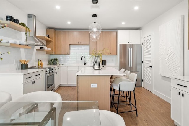 20 Audubon Way Unit 208, Canton, MA 02021 - kitchen featuring wall chimney exhaust hood, stainless steel appliances, open shelves, light wood-style flooring, and a center island