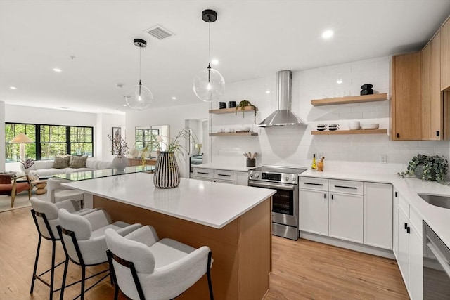 20 Audubon Way Unit 208, Canton, MA 02021 - kitchen featuring stainless steel appliances, open shelves, wall chimney range hood, a kitchen island, and decorative backsplash