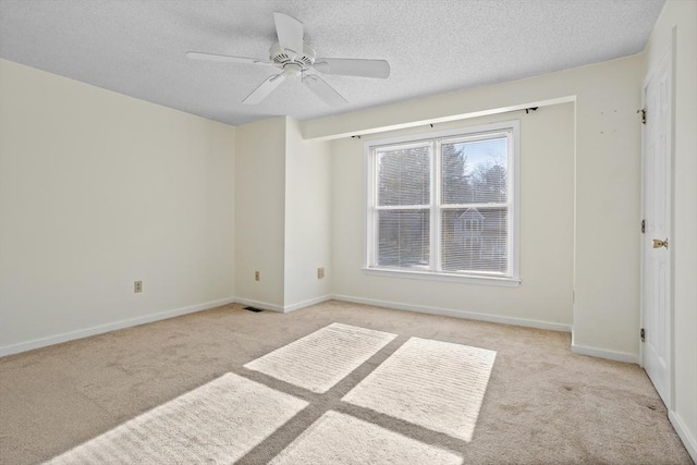 carpeted spare room featuring ceiling fan and a textured ceiling