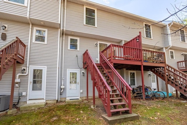 back of house with cooling unit and a deck