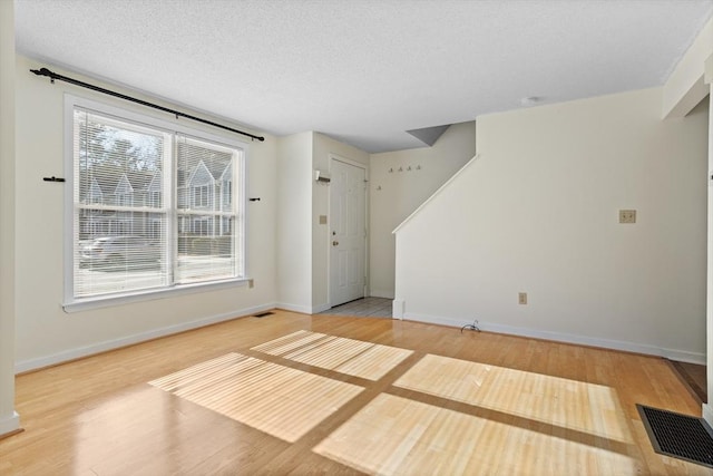 interior space featuring a textured ceiling and hardwood / wood-style flooring