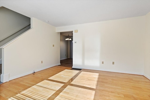 empty room featuring hardwood / wood-style floors and a notable chandelier