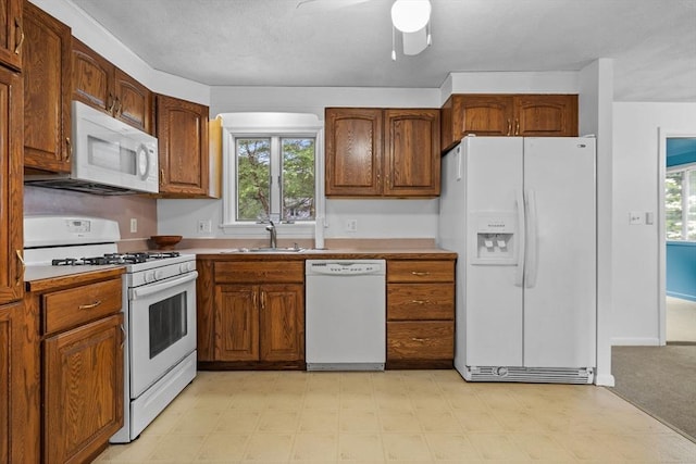 23 Eastview Ave, Billerica, MA 01821 - kitchen featuring white appliances, light floors, ceiling fan, and brown cabinets
