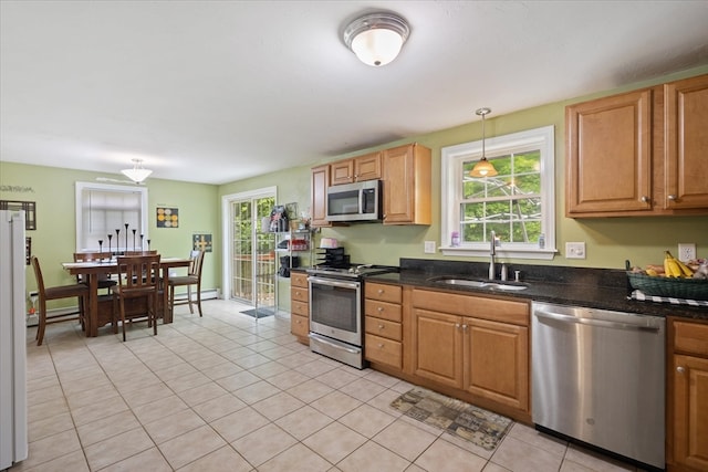 kitchen featuring stainless steel appliances, sink, hanging light fixtures, a baseboard radiator, and light tile patterned flooring