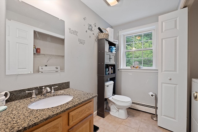 bathroom featuring tile patterned flooring, washer / clothes dryer, toilet, vanity, and baseboard heating