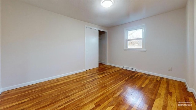 unfurnished bedroom with hardwood / wood-style flooring and a closet