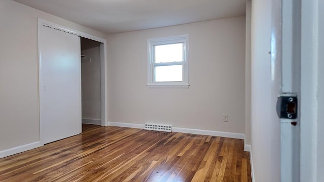 unfurnished bedroom featuring a closet and dark wood-type flooring