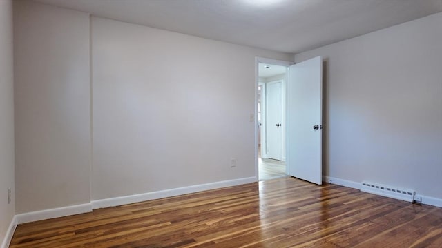 empty room with dark hardwood / wood-style flooring