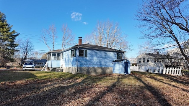 view of property exterior with a lawn and central AC