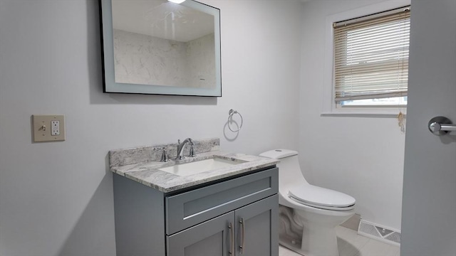 bathroom with tile patterned flooring, vanity, and toilet