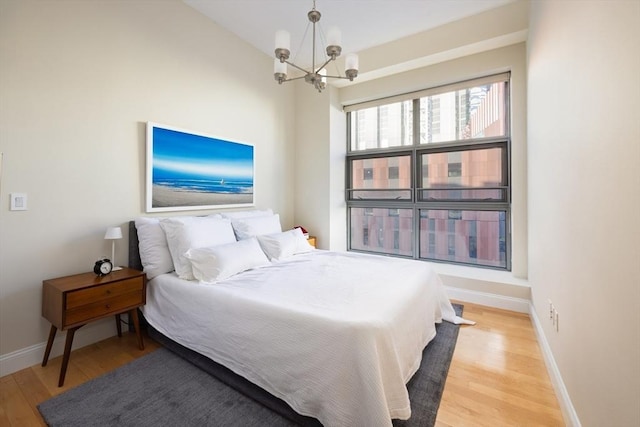 bedroom with a chandelier and light hardwood / wood-style flooring