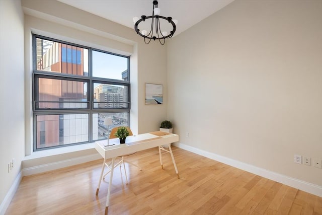 office area featuring plenty of natural light, light wood-type flooring, and a chandelier