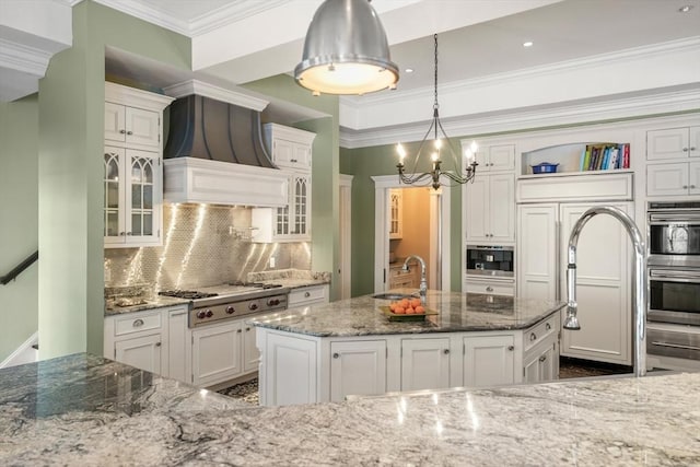 kitchen featuring glass insert cabinets, ornamental molding, stainless steel appliances, white cabinetry, and a sink