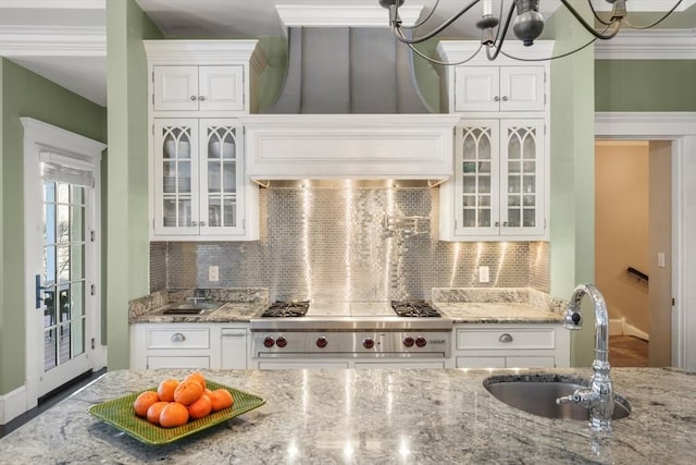 kitchen with designer stove, glass insert cabinets, white cabinets, and a sink