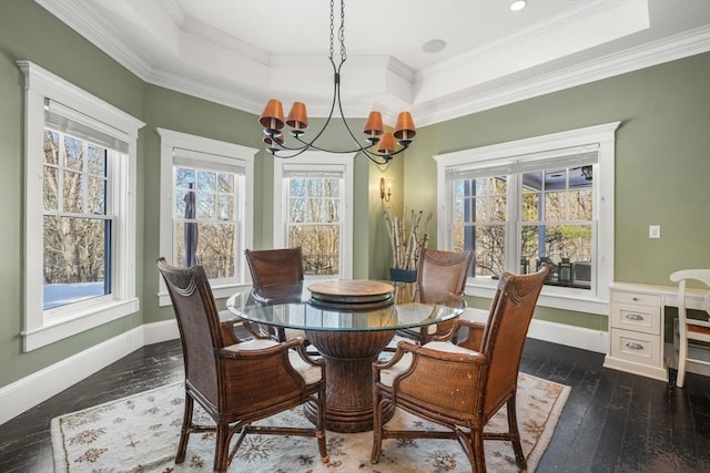 dining room with a chandelier, a tray ceiling, crown molding, and dark wood finished floors