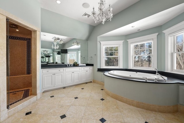 full bathroom with a wealth of natural light, a garden tub, visible vents, and an inviting chandelier