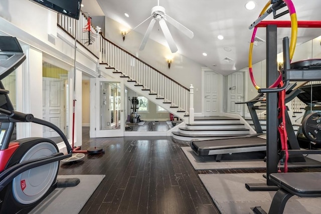 exercise room featuring visible vents, a ceiling fan, a towering ceiling, wood finished floors, and recessed lighting