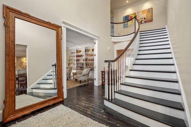 interior space featuring a towering ceiling, stairway, and wood finished floors