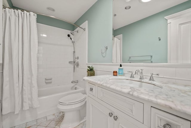 bathroom featuring marble finish floor, shower / tub combo with curtain, vanity, and toilet