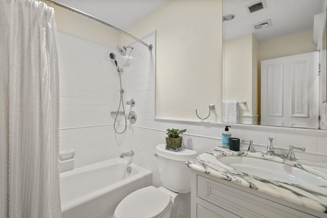 full bathroom featuring toilet, shower / bathtub combination with curtain, visible vents, and vanity