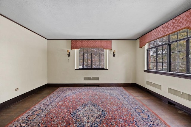 spare room with visible vents, baseboards, and hardwood / wood-style flooring