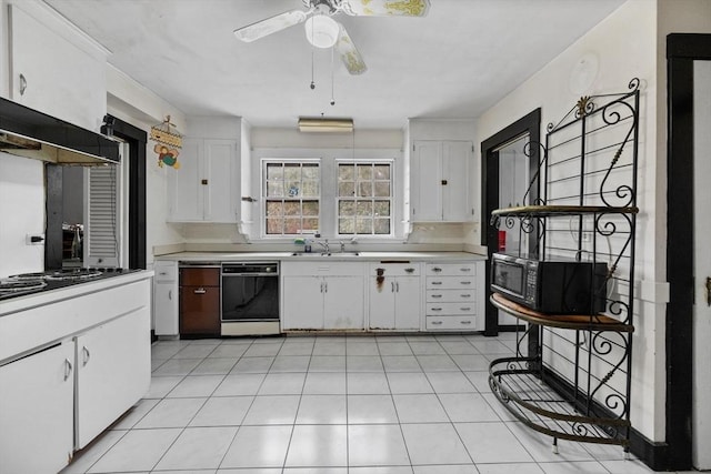 kitchen with light tile patterned floors, a sink, white cabinetry, light countertops, and black appliances