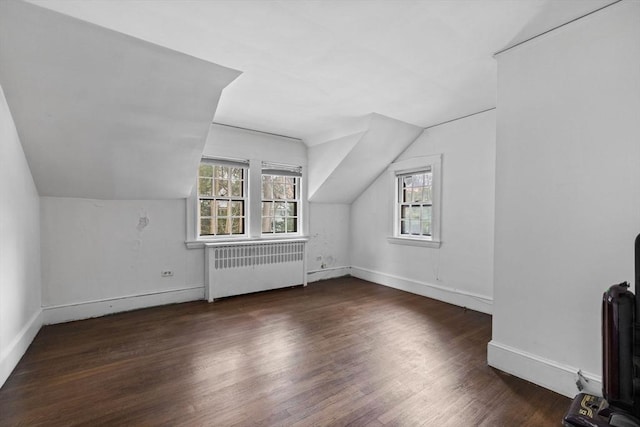 bonus room featuring radiator, vaulted ceiling, baseboards, and wood finished floors