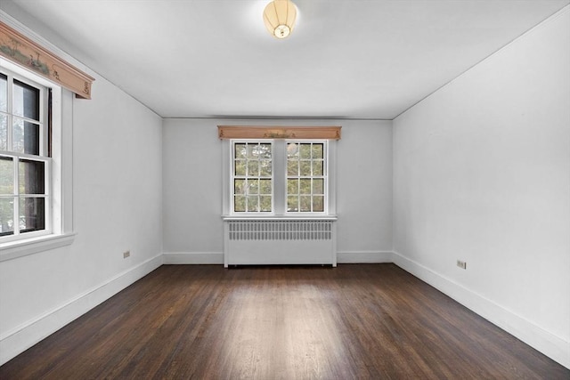 empty room featuring radiator, baseboards, and wood finished floors