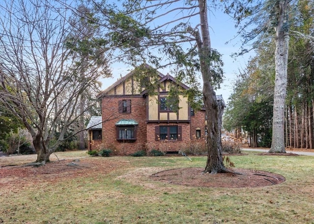 view of front of house with a front yard and brick siding