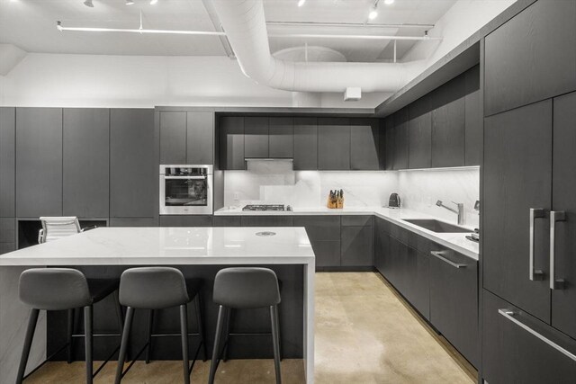 437 D St Unit 4F, Boston, MA 02210 - kitchen with stainless steel appliances, a sink, concrete flooring, a breakfast bar, and modern cabinets