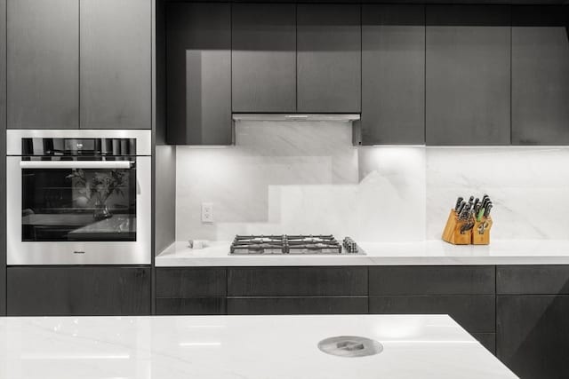 437 D St Unit 4F, Boston, MA 02210 - kitchen featuring appliances with stainless steel finishes, backsplash, light countertops, modern cabinets, and gray cabinets