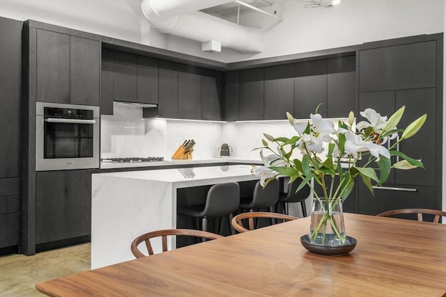 437 D St Unit 4F, Boston, MA 02210 - kitchen featuring oven, gas stovetop, a breakfast bar area, and modern cabinets