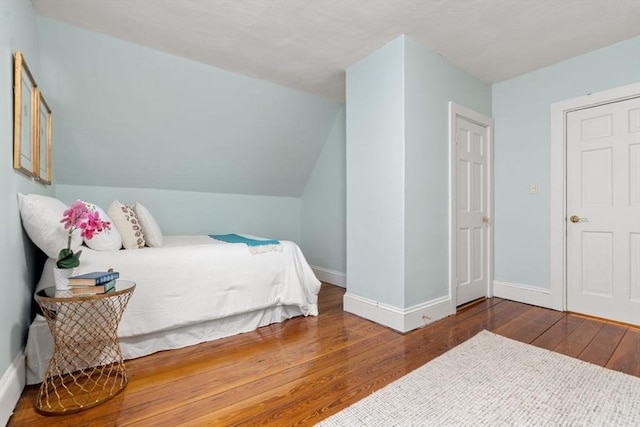 bedroom featuring lofted ceiling and wood-type flooring