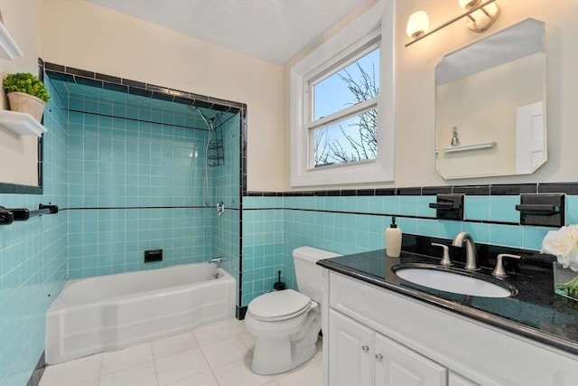 full bathroom featuring tile patterned floors, toilet, tile walls, vanity, and tiled shower / bath combo