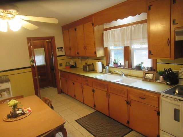 kitchen with light countertops, light tile patterned floors, electric range, a ceiling fan, and a sink