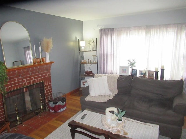 living room with a fireplace, wood finished floors, and baseboards