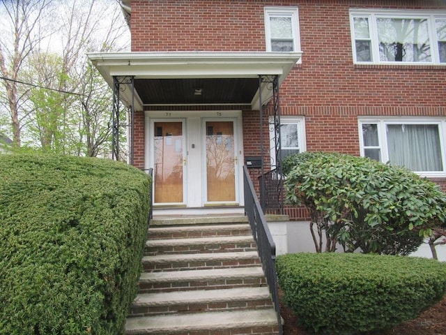 doorway to property with brick siding