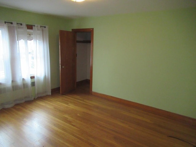 unfurnished bedroom with light wood finished floors, a closet, and baseboards