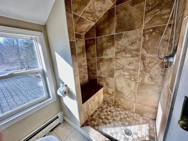 bathroom with tiled shower, tile patterned flooring, a wealth of natural light, and a baseboard heating unit