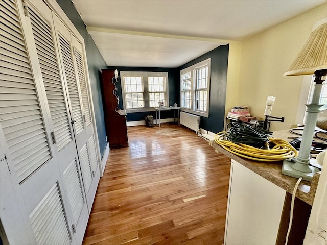 hall featuring light wood-type flooring and radiator