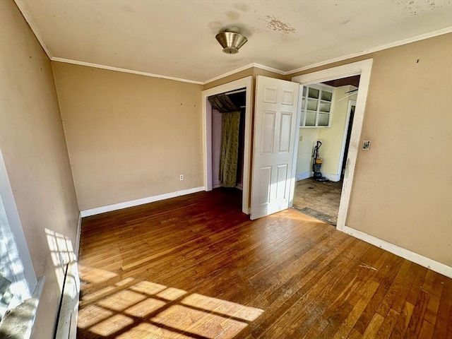 unfurnished bedroom with a closet, hardwood / wood-style floors, and crown molding