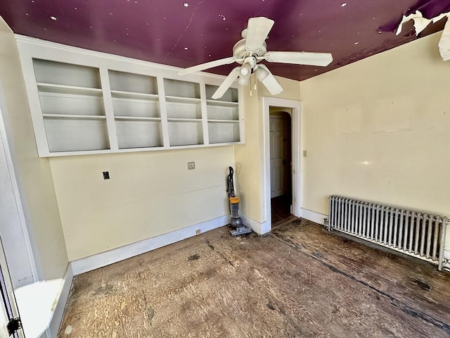 unfurnished room featuring radiator and ceiling fan