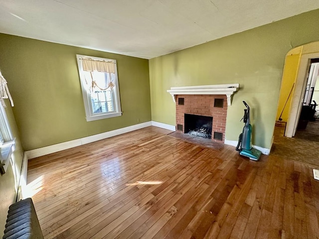 unfurnished living room featuring a fireplace and hardwood / wood-style floors