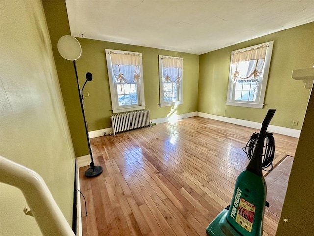 interior space with radiator, a wealth of natural light, and light hardwood / wood-style floors